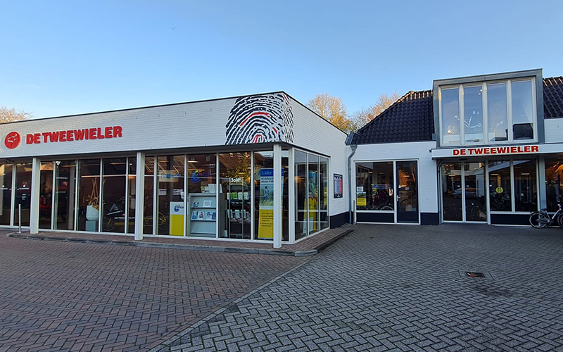 pand in Udenhout vanaf de buitenzijde gezien. Wit met in rood de naam van het bedrijf